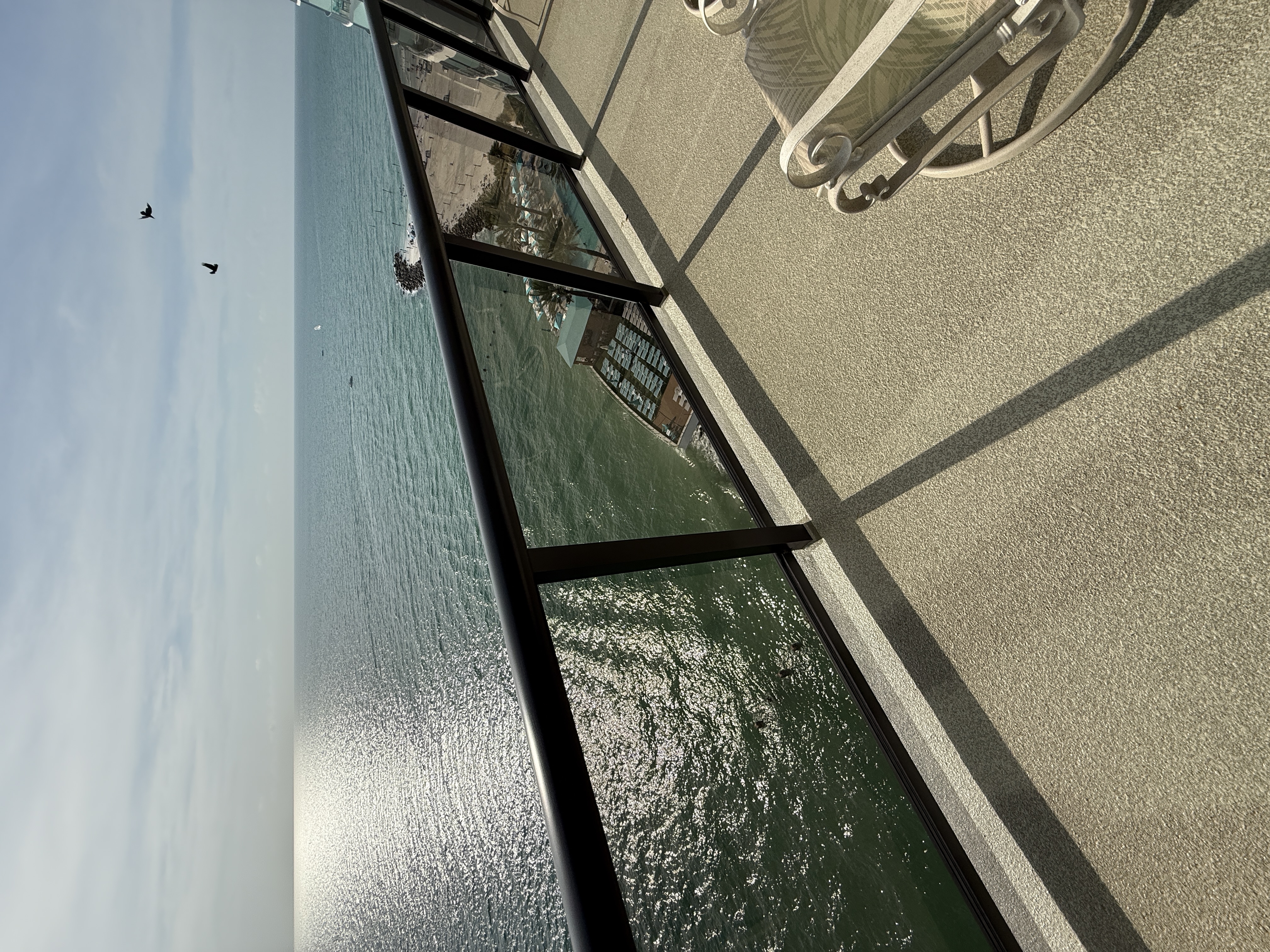 Balcony chairs and table with beach view